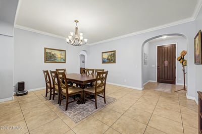 This inviting dining room features stylish lighting, generous space for gatherings, and an open layout that enhances the home's comfortable flow while connecting seamlessly to the surrounding living areas.