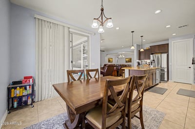 This inviting breakfast area features large windows, backyard views, and convenient access to outdoor living spaces. A perfect spot for dining while enjoying the home's bright, open design.
