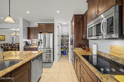 Designed for both style and function, this gourmet kitchen showcases granite countertops, stainless steel appliances, extensive cabinetry, and a spacious walk-in pantry. Its open layout makes meal preparation and entertaining effortless.