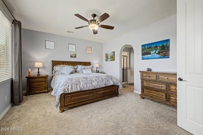 The spacious owner's suite offers plush carpeting, soaring ceilings, large windows, and direct access to the luxurious en-suite bathroom, creating a relaxing retreat in this Goodyear rental property.