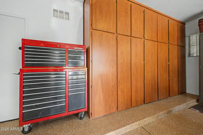 Extensive wall-to-wall cabinetry maximizes garage organization while epoxy flooring provides durability and easy upkeep. A standout feature for this well-maintained rental home in Goodyear.