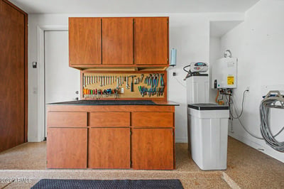 Built-in cabinets, countertop workspace, pegboard tool organization, and utility systems create a functional garage designed for projects, storage, and everyday convenience in Goodyear.