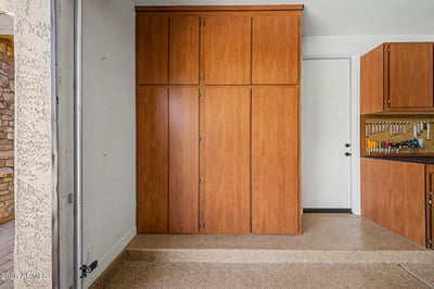 Large custom storage cabinets keep seasonal items, tools, and equipment neatly organized while preserving valuable garage space. A practical feature of this Goodyear rental property.