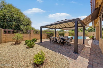 Relax beneath the covered gazebo overlooking the beautifully landscaped backyard with paver patios and easy-care desert landscaping. An outstanding outdoor entertaining space in Goodyear.