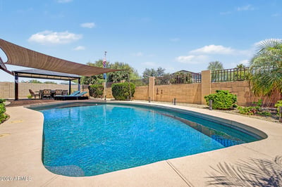 Another perspective showcases the private pool, covered gazebo, shade sail, and professionally landscaped backyard designed for relaxing, entertaining, and enjoying outdoor living in Goodyear.