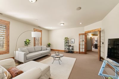 VIRTUAL STAGING. This photo of the Bonus Room has been altered to reflect lighter wall paint and contemporary furnishings.
