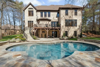 VIRTUALLY STAGED: Staircase from deck, pool with stone surround and landscaping enhance the current grass back yard to reflect the beautiful possibilities for this space.