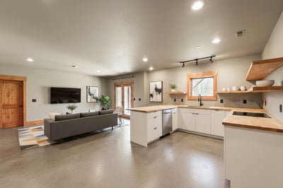 VIRTUAL STAGING: This photo has been enhanced to add kitchen and furnishings to the space. It is currently plumbed for h/c water and additional electrical outlets to support appliances.