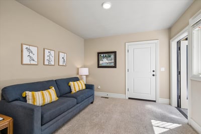 The lower level features this separate family room / flex room, with views to an additional private patio and garden.