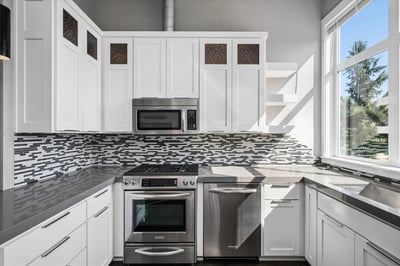 White cabinets, dishwasher, hardwood floors.