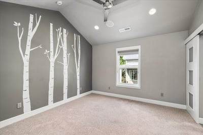 Primary suite with a vaulted ceiling, ceiling fan, walk-in closet and private bathroom.