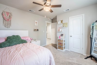 Bright bedroom featuring soft textures, a ceiling fan, and easy access to adjoining spaces.