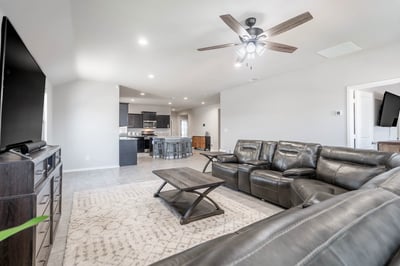 Spacious living area featuring modern finishes, a cozy sectional, and seamless flow to the kitchen.