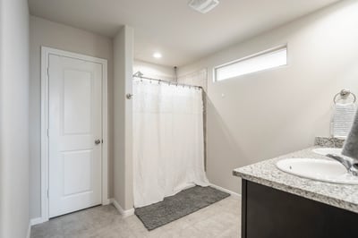 Bright and functional bathroom featuring modern finishes, a spacious shower area, and ample counter space.