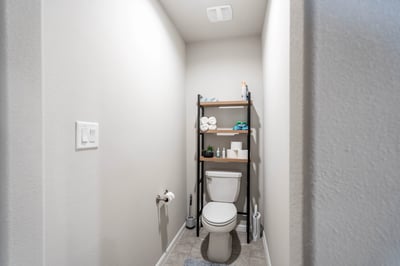 This functional bathroom features a compact layout with essential amenities and organized shelving for convenience.