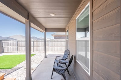 Relax on the spacious porch overlooking a private yard, perfect for outdoor gatherings and leisure.