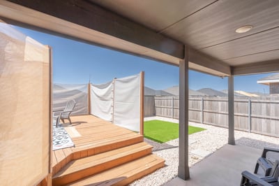 Modern outdoor space featuring a private deck, lush green area, and mountain views for relaxation.