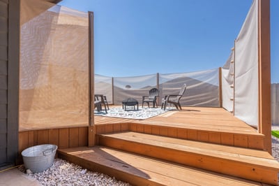 Discover a private outdoor retreat featuring a spacious deck and cozy seating area, perfect for relaxation.