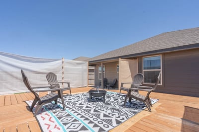 Spacious outdoor deck with seating and a fire pit, perfect for gatherings and relaxation.