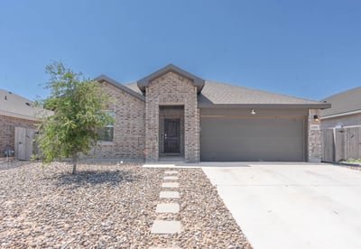 This modern brick home features a spacious driveway, low-maintenance landscaping, and a welcoming entrance.