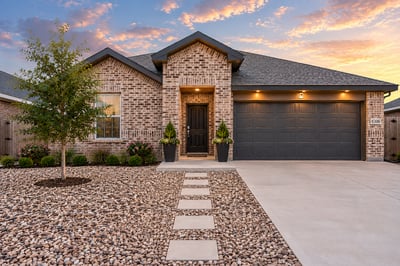 Contemporary brick home featuring a landscaped front yard and modern garage, perfect for suburban living.