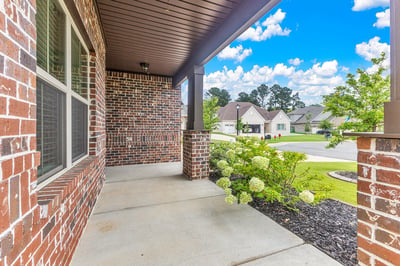 Welcoming front porch with brick accents, perfect for enjoying the neighborhood views and fresh air.
