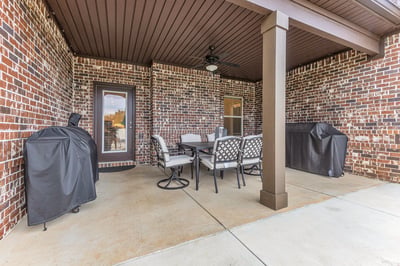 Spacious covered patio offers ample seating and grill areas, perfect for entertaining and enjoying outdoor meals.