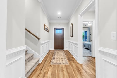 Welcoming entryway features a bright hallway with LVP floors, leading to inviting living spaces upstairs.