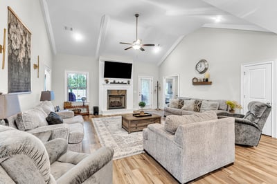 Spacious living room featuring a cozy fireplace, large windows, and ample seating for relaxation and entertainment.