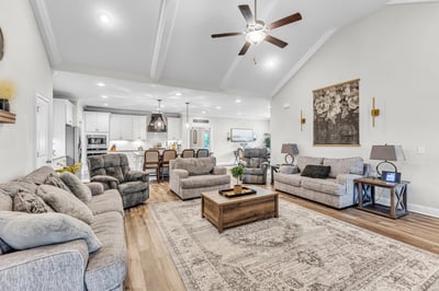 Spacious living area with vaulted ceilings, modern kitchen access, and cozy seating for family gatherings.