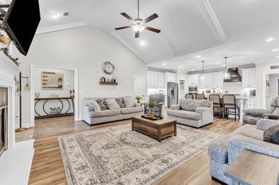 Spacious open-concept living area featuring high ceilings, modern kitchen access, and comfortable seating arrangements.