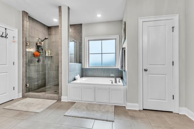 Spacious bathroom featuring a large soaking tub and a modern walk-in shower with abundant natural light.