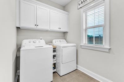 Bright and functional laundry space featuring modern appliances and ample storage options for convenience.