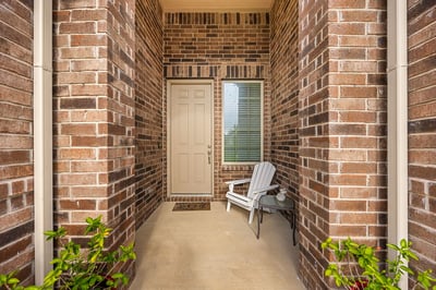 Welcoming entrance featuring spacious brickwork and a cozy seating area for relaxation.