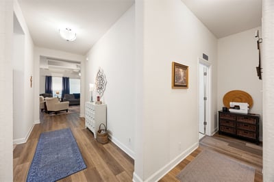 Spacious entryway leading to an inviting living area, featuring modern finishes and warm wood flooring.
