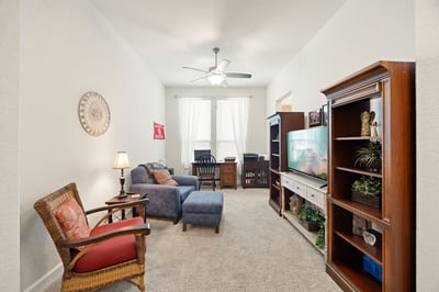 Spacious living area with natural light, featuring comfortable seating and built-in shelving for added storage.