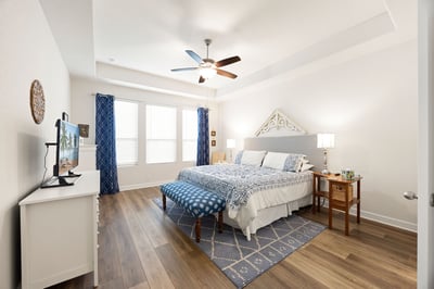 Spacious bedroom featuring large windows, modern decor, and ample natural light for a comfortable retreat.