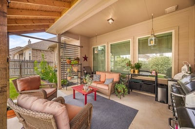 Discover a cozy outdoor living space featuring comfortable seating and lush greenery, perfect for relaxation.