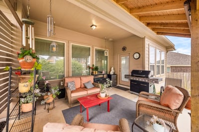 Spacious covered patio featuring comfortable seating, vibrant plants, and an outdoor grill for entertaining.