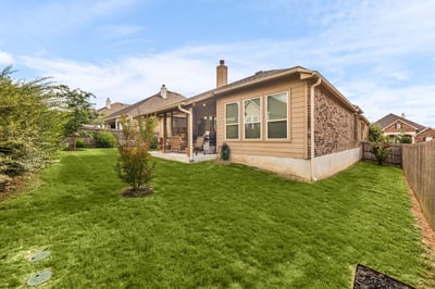Spacious backyard perfect for outdoor gatherings, featuring a patio and lush green landscaping.