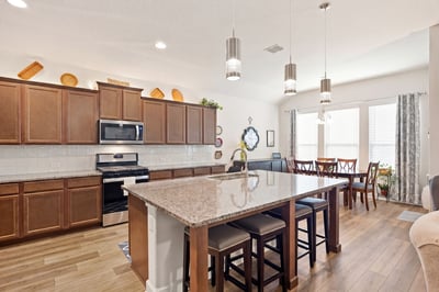 Modern kitchen with spacious island, sleek cabinetry, and abundant natural light, perfect for gatherings and cooking.