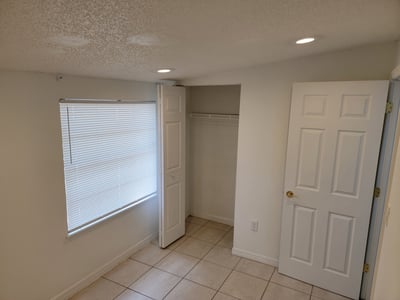 Bright room featuring ample natural light, a spacious closet, and modern tile flooring throughout.