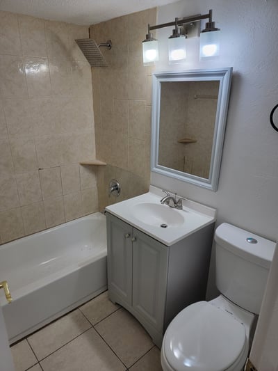 Bright bathroom featuring modern fixtures, tiled walls, and a clean design for a functional space.