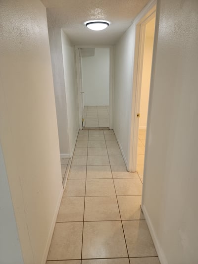 Bright hallway featuring tiled flooring and easy access to adjoining rooms, enhancing the home's functionality.