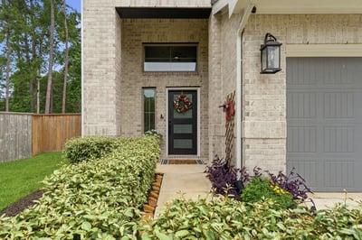Beautiful modern front door and lovely landscaping.