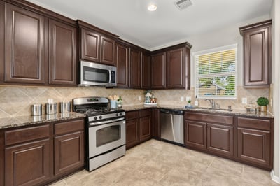 Modern kitchen featuring rich cabinetry, stainless steel appliances, and ample countertop space for cooking and entertaining.