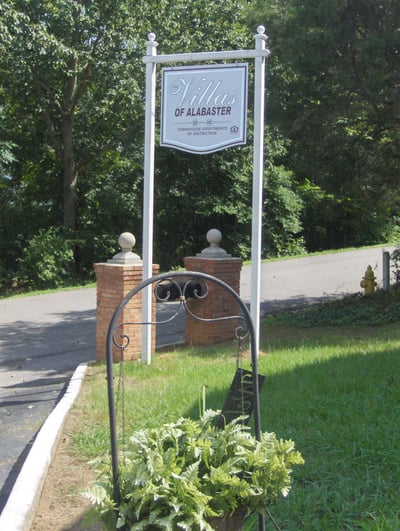 Discover the inviting entrance to Villas of Alabaster, featuring lush greenery and a welcoming atmosphere.