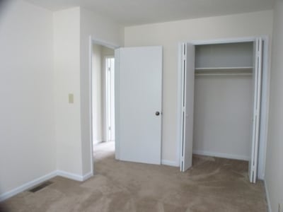 Bright, open bedroom featuring a spacious closet and easy access to natural light from adjacent rooms.