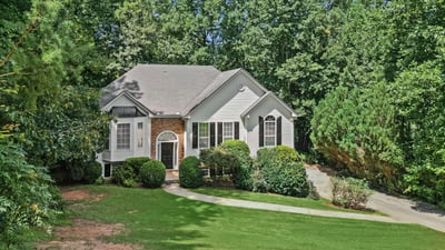 Spacious home surrounded by lush greenery, featuring ample natural light and inviting outdoor spaces.