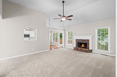 Spacious living area with a cozy fireplace and abundant natural light, perfect for gatherings and relaxation.